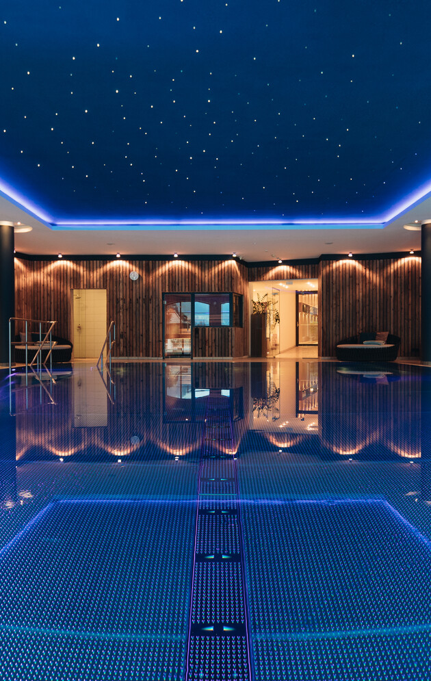 Indoor-Pool mit Sternenhimmel und gemütlichen, großzügigen Liegen im 4*S Wellnesshotel Nesslerhof in Großarl, Salzburger Land